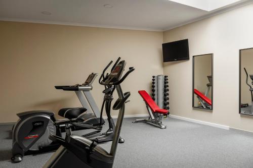 a gym with two treadmills and two exercise bikes at EXE Wellington in Figueira da Foz