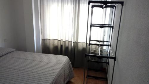 a bedroom with a bed and a ladder next to a window at Plaza de España in Salamanca