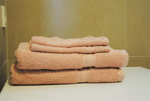 un montón de toallas sentadas en un mostrador en un baño en Rose Apartment en Pärnu