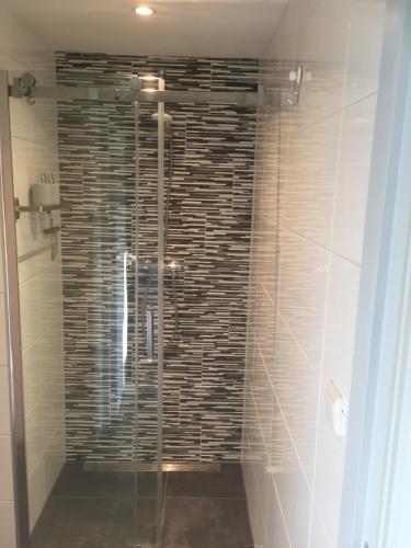 eine Dusche mit Glastür im Bad in der Unterkunft B&B Nagele in Nagele