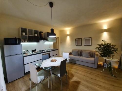 eine Küche und ein Wohnzimmer mit einem Tisch und einem Sofa in der Unterkunft 6 Via della Rosa in Lucca