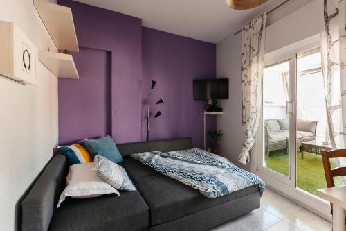 a living room with purple walls and a couch at Penthouse Apartment in Barcelona