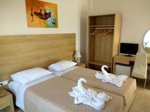 um quarto de hotel com duas camas com toalhas em International Hotel in Ilha de Rhodes