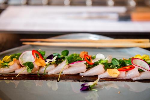 two plates of food on a table with chopsticks at Schweizerhof Zermatt - a Small Luxury Hotel in Zermatt