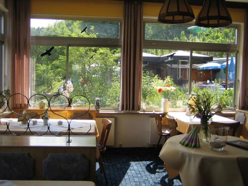 a restaurant with two tables and a large window at Landhotel Weinhaus Treis in Weinähr