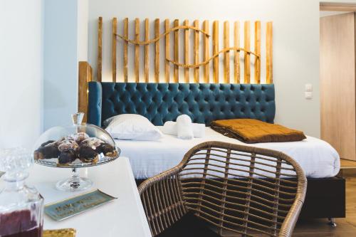 a bedroom with a bed with a blue headboard and a table at Dome Rooms Downtown in Chania