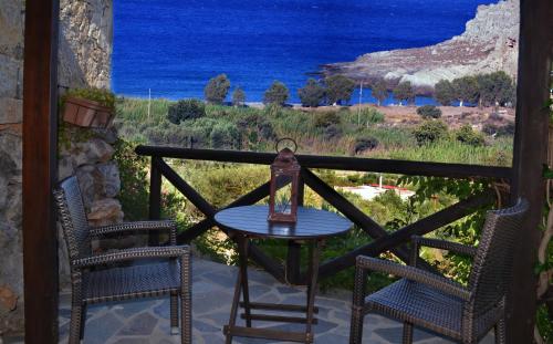 a table and two chairs on a balcony with the ocean at Katerina Apartments in Káto Zákros