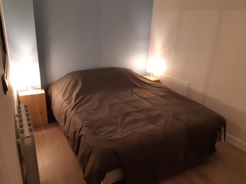 - un lit dans une petite chambre avec deux lampes dans l'établissement ROUEN SWEET HOME 2, à Rouen