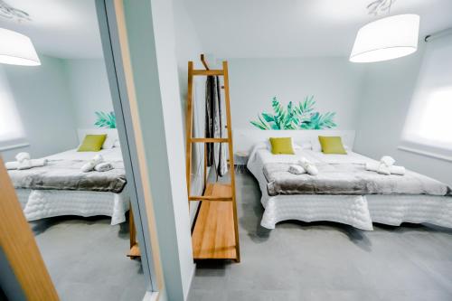 a room with two beds and a mirror at Casa Rural Peña Gamella in Herreros