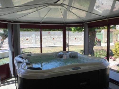 - un bain à remous sous un parasol sur la terrasse dans l'établissement Domaine du Clos Pallacien, à Paillé