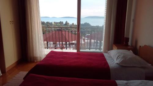 a bedroom with a bed and a large window at Apartments Pilić in Šibenik