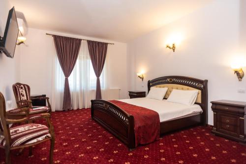 a hotel room with a bed and a chair at Tango margo in Iaşi