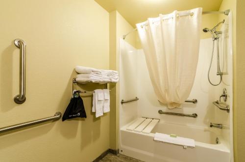 a bathroom with a shower and a tub with a shower curtain at Cobblestone Inn & Suites - Ord in Ord