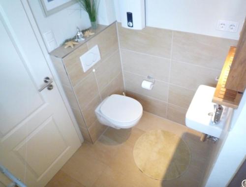 a small bathroom with a toilet and a sink at Seependance in Grömitz