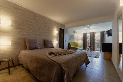 a bedroom with a large bed and a living room at Villa Welwitshia in Carvoeiro