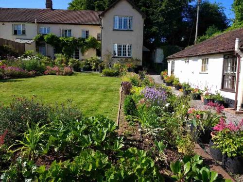 a garden in front of a house with flowers at Brambles Bed and Breakfast in Tiverton