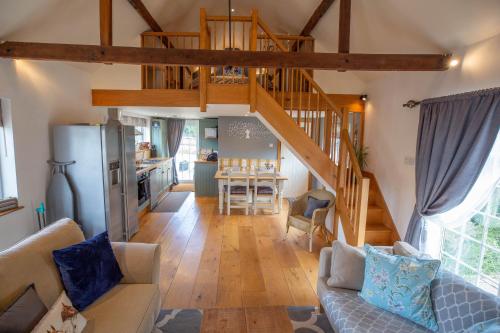 a living room with a staircase and a kitchen at Cherry Orchard Lodge in Bath
