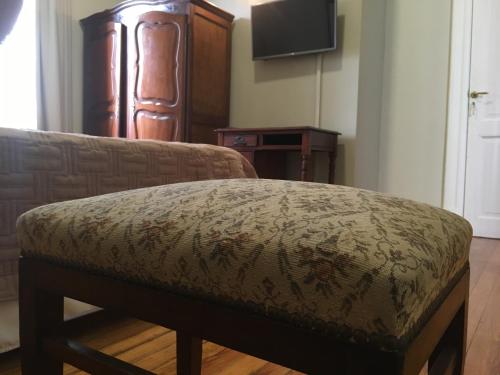 an ottoman in a living room with a television at Bar de Fondo Suites in Buenos Aires