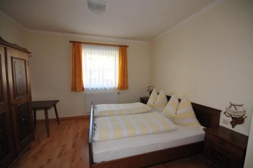 a bedroom with a bed with pillows and a window at Appartement Seiwald in Leogang