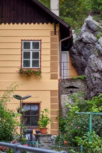 a yellow house with a window and a rock at Haus zum Prater in Spitz