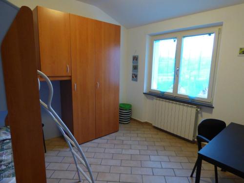 a room with wooden cabinets and a table and a window at B&B Podere Montese in Villafranca in Lunigiana