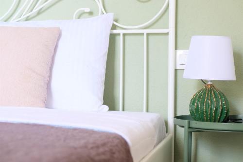 a bedroom with a bed and a table with a lamp at Apartment Mint&Rose in Risan