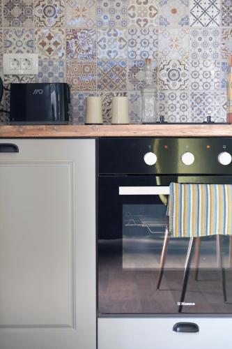 a kitchen with a counter with a stove and a chair at Apartment Mint&Rose in Risan