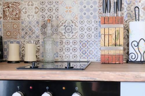 a kitchen counter with a counter top with a tile wall at Apartment Mint&Rose in Risan