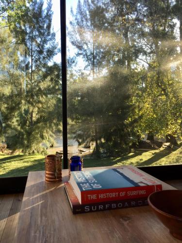 a stack of books sitting on a table in front of a window at Cabañas Isla San Jose in Tigre