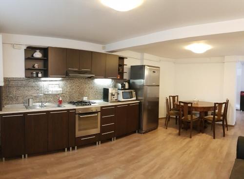 a kitchen and dining room with a table in it at Central Park Apartments in Braşov