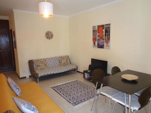 a living room with a couch and a table at Apartamento Praia dos Salgados in Albufeira