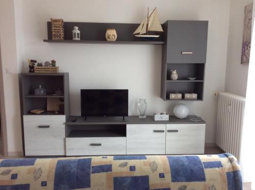 ein Schlafzimmer mit einem großen Entertainment-Center mit einem TV in der Unterkunft Portese la terrazza di Piero in San Felice del Benaco