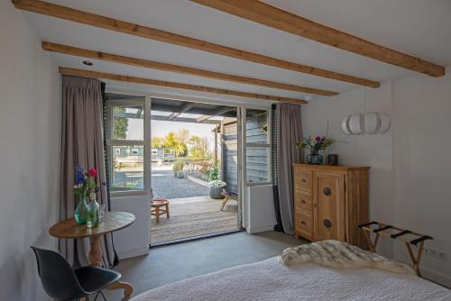 a bedroom with a bed and a door to a patio at Studio Haarlemenmeer in Cruquius