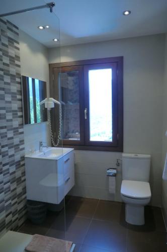 a bathroom with a toilet and a sink and a window at Pension Malida in Casau