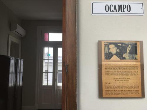 a sign on a wall with a picture of an old photo at Bar de Fondo Suites in Buenos Aires