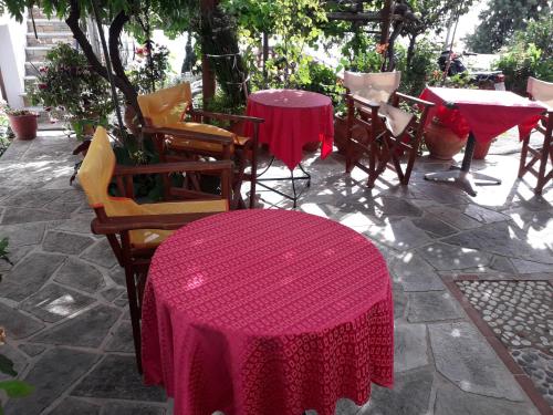 Vera's Traditional House في زاغورا: مجموعة من الطاولات والكراسي مع قماش الطاولة وردي