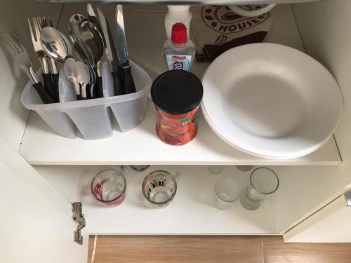 a shelf with a bowl and utensils on it at Pousada Tchê Aprochega in Pelotas