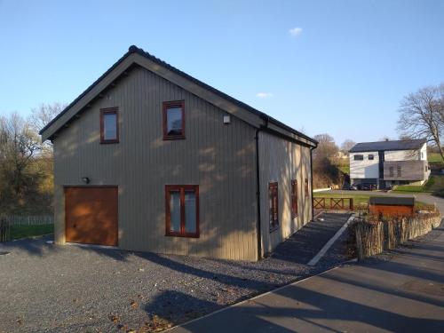 un petit bâtiment métallique sur le côté d'une route dans l'établissement Gezellige chalet in Hoge Venen, à Uberweywertz