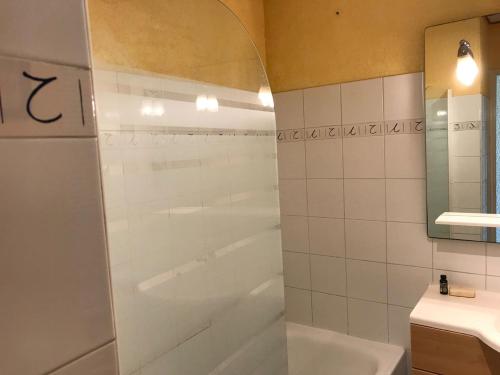 uma casa de banho com um chuveiro, uma banheira e um lavatório. em Goelands em Palavas-les-Flots