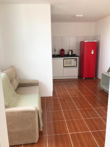 a living room with a couch and a red refrigerator at Pousada Tchê Aprochega in Pelotas