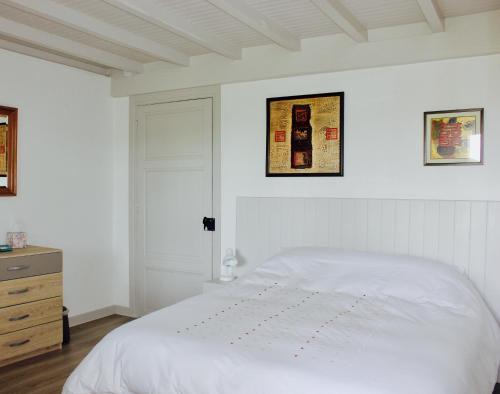een witte slaapkamer met een bed en een dressoir bij Castel Rouge in Luzech