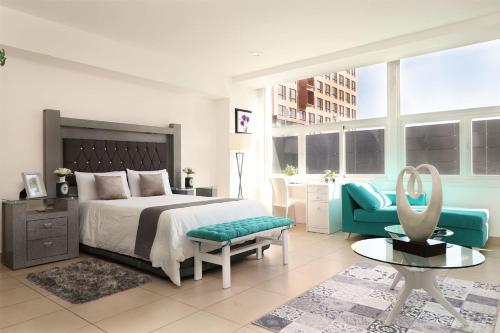a bedroom with a bed and a chair and a table at Premier apartment in the heart of Mexico 802 in Mexico City