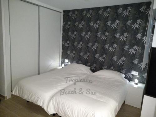 a bedroom with a bed with a black and white wallpaper at Tropicana Beach & Sun in Torrox Costa