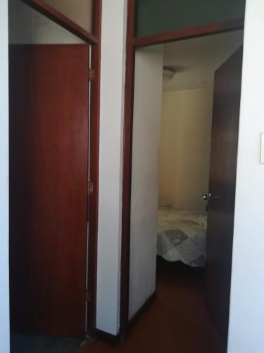 Habitación con armario y puerta con cama en Mini Departamento Tambo Huascar 2, en Lima