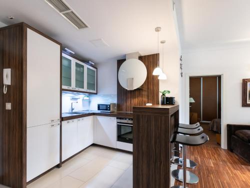 eine Küche mit weißen Schränken sowie einem Tisch und Stühlen in der Unterkunft VacationClub – Olympic Park Apartament B8 in Kołobrzeg