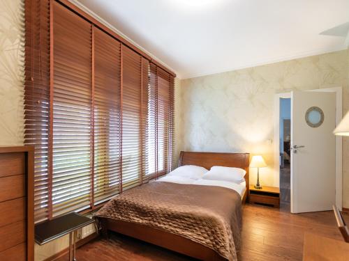 ein Schlafzimmer mit einem Bett und einem großen Fenster in der Unterkunft VacationClub – Olympic Park Apartament B8 in Kołobrzeg