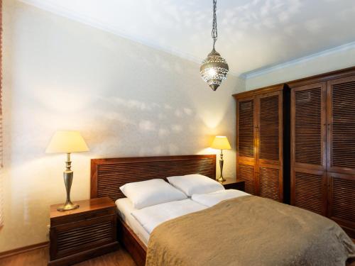 ein Schlafzimmer mit einem Bett, zwei Lampen und einem Kronleuchter in der Unterkunft VacationClub – Olympic Park Apartament B8 in Kołobrzeg
