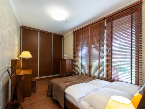 ein Schlafzimmer mit einem Bett und einem großen Fenster in der Unterkunft VacationClub – Olympic Park Apartament B8 in Kołobrzeg