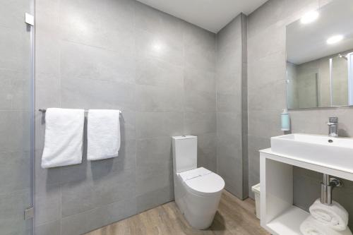 a bathroom with a white toilet and a sink at D' El Rei B&B in Matosinhos