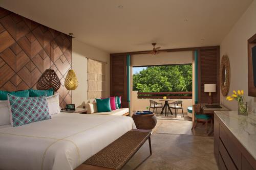 a bedroom with a large bed and a living room at Secrets Maroma Beach Riviera Cancun - Adults only in Playa del Carmen